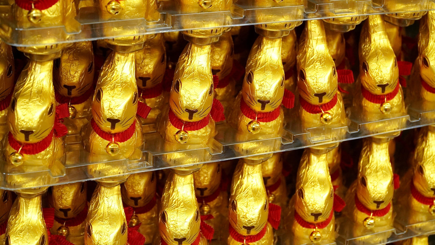 golden chocolate bunnies in a row on shelves 