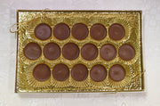 Box of milk chocolate meltawys with gold wrapping on a white surface