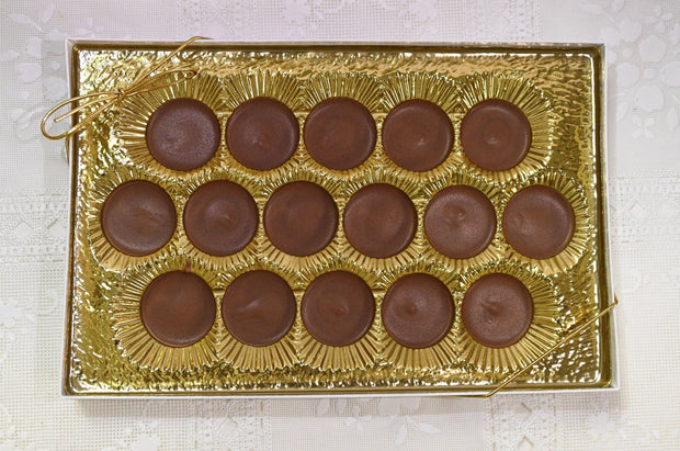 Box of milk chocolate meltawys with gold wrapping on a white surface
