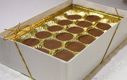 Box of milk chocolate meltawys with gold wrapping on a white surface